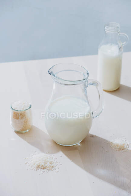 Банка молока и риса на столе — стоковое фото
