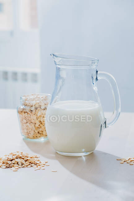 Pot de flocons de lait et d'avoine sur la table — Photo de stock