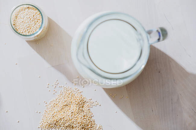 Pot de lait et flocons d'avoine sur la table — Photo de stock