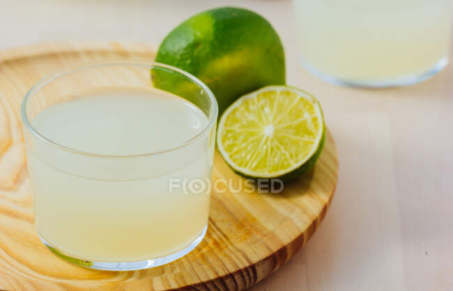 Homemade refreshing lemonade in glass with fresh lime — Stock Photo