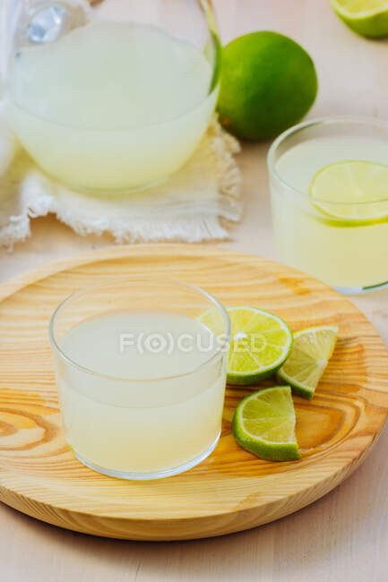 Limonada refrescante casera en vasos con rodajas de lima - foto de stock