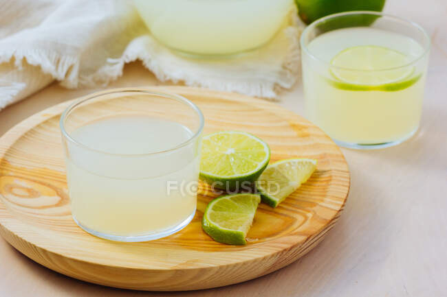 Homemade refreshing lemonade in glasses with slices of lime — Stock Photo