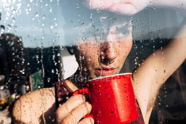 Nachdenkliche Frau trinkt Kaffee am Fenster — Stockfoto