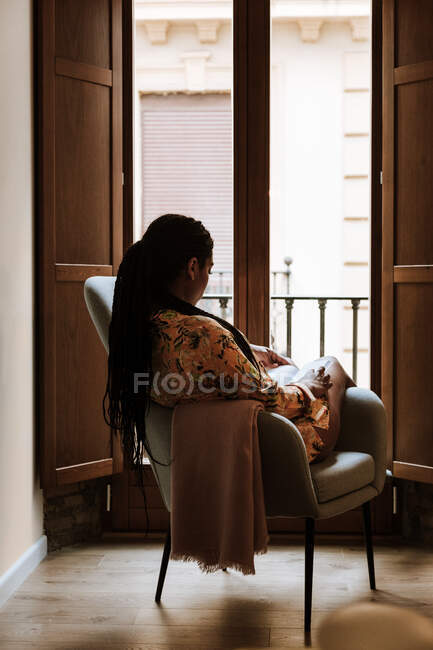 Donna etnica con libro a riposo a casa — Foto stock