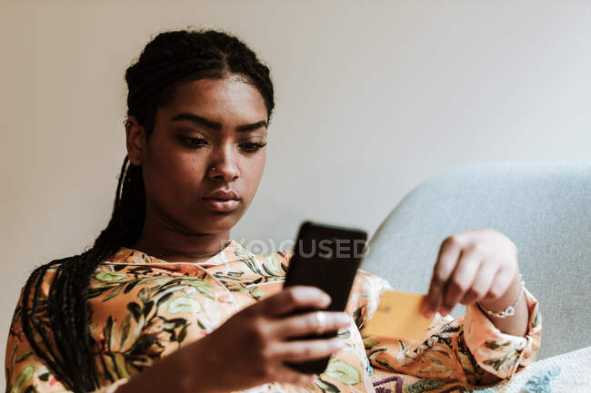 Femme ethnique faisant du shopping en ligne à la maison — Photo de stock