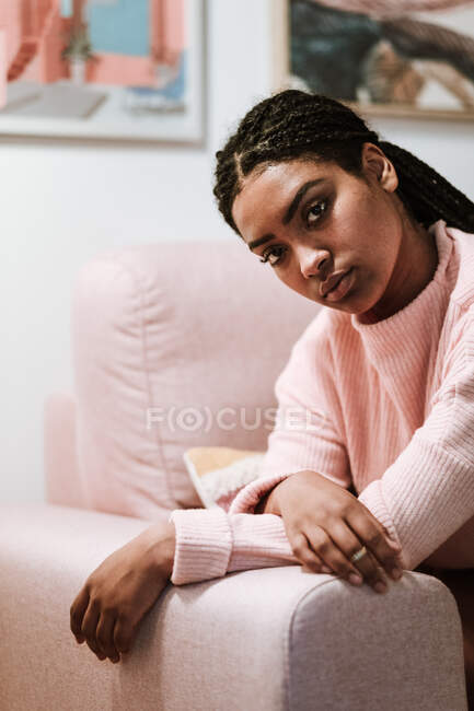 Mujer joven aburrida sentada en el sofá - foto de stock