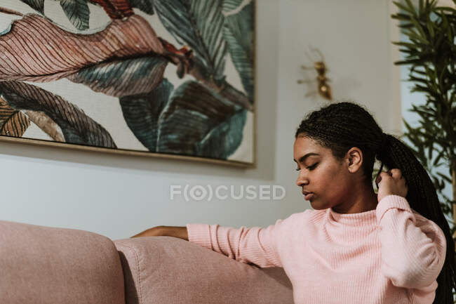 Jovem entediada sentada no sofá — Fotografia de Stock