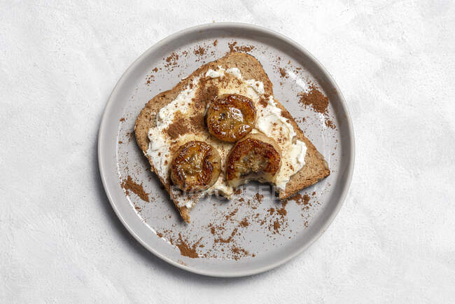 Домашний жареный хлеб сверху со сливочным сыром, жареным бананом, медом и корицей.. — стоковое фото