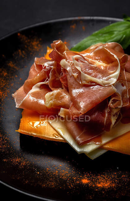 Homemade toasted bread with ham and different types of cheeses on dark background — Stock Photo