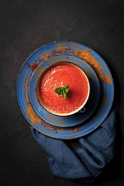 Zuppa di pomodoro fatta in casa sana con pane, menta e olio d'oliva su sfondo scuro dall'alto. — Foto stock