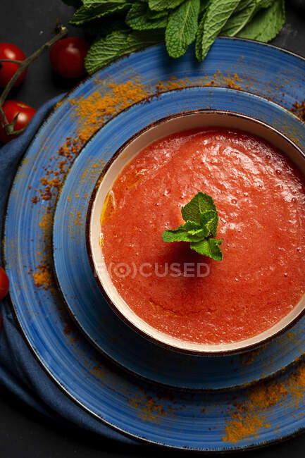 Sopa de tomate caseira saudável com pão, hortelã e azeite no fundo escuro de cima. Conceito de comida Vegan — Fotografia de Stock