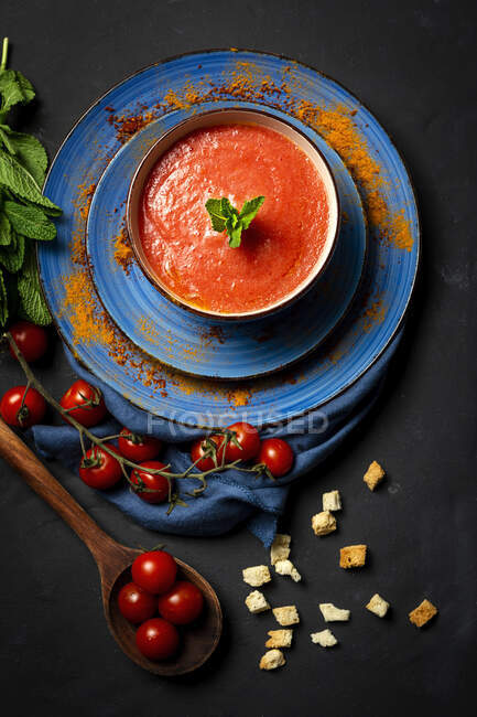 Soupe de tomates maison saine au pain, à la menthe et à l'huile d'olive sur fond sombre. Concept de nourriture végétalienne — Photo de stock