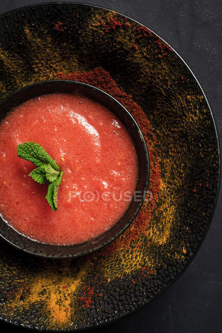 Zuppa di pomodoro fatta in casa sana con pane, menta e olio d'oliva su sfondo scuro dall'alto. Concetto di cibo vegano — Foto stock