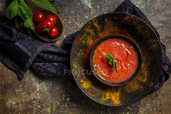 Gesunde hausgemachte Tomatensuppe mit Brot, Minze und Olivenöl auf dunklem Hintergrund von oben. Veganes Ernährungskonzept — Stockfoto