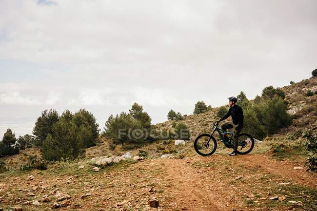 Cyclist riding bike on rocky path in forest — Stock Photo