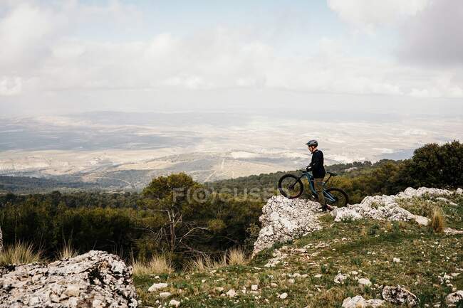 Цикліст їде на велосипеді по скелястій стежці лісу. — стокове фото