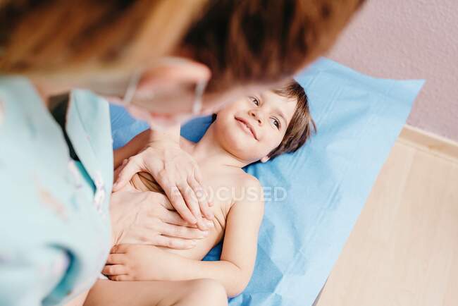 Медсестра осматривает маленького мальчика в клинике — стоковое фото