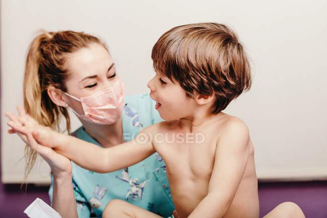 Happy nurse and kid in clinic — Stock Photo