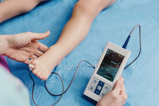 Doctor with oximeter examining little patient — Stock Photo