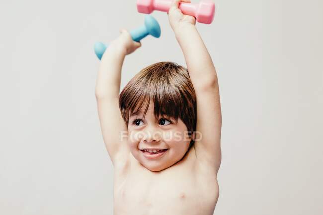 Petit garçon joyeux avec des haltères — Photo de stock