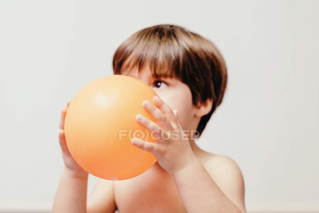 Little boy with balloon sitting on blanket — Stock Photo