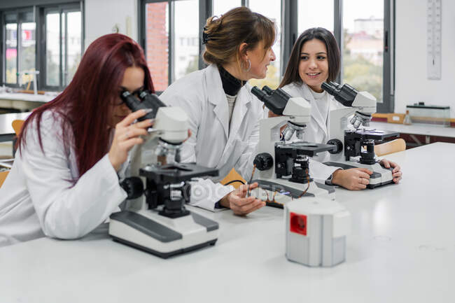 Female scientists using microscopes in lab — Stock Photo