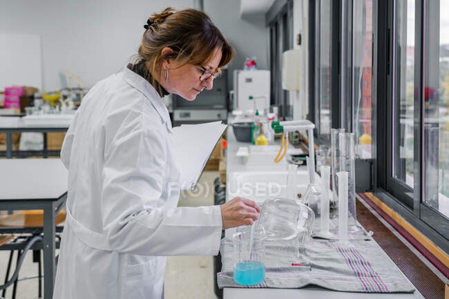 Взрослая женщина работает в лаборатории химии — стоковое фото