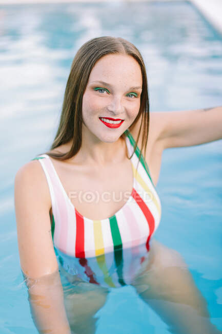Gros plan d'une fille brune aux cheveux longs dans un escalier de la piscine — Photo de stock