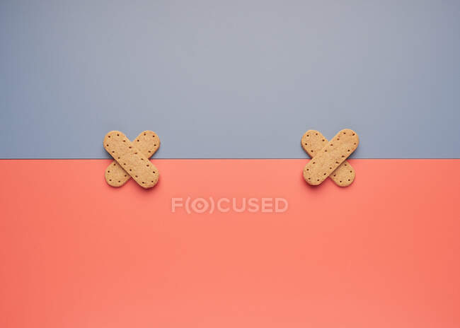 Knusprige Kekse auf grauen und korallenen Papierbögen — Stockfoto