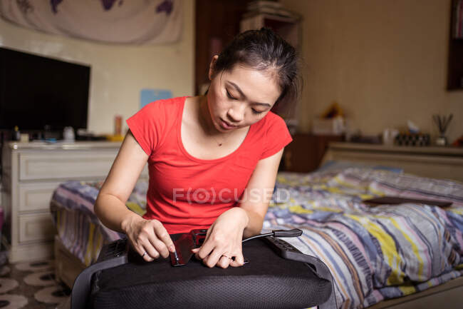 Jovem fêmea asiática étnica com anel no dedo mindinho transformando parafuso durante a instalação de alça na cadeira em casa — Fotografia de Stock