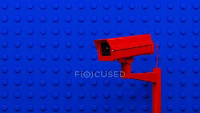 Caméra de surveillance rouge sur fond bleu surveillant les gens dans la rue. Caméra pour rechercher les délinquants en quarantaine causés par le coronavirus — Photo de stock