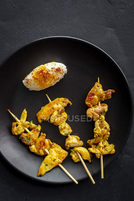 Homemade Moorish skewers with rice of meat with spices. Typical oriental food from above on dark background. Flat lay. Top view — Stock Photo