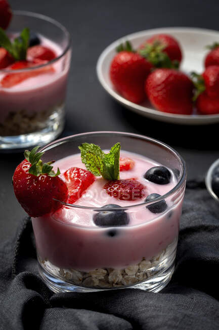 Homemade yogurt with strawberries, blueberries and cereals with dark background and sunlight.Healthy food concept.Vegan food — Stock Photo