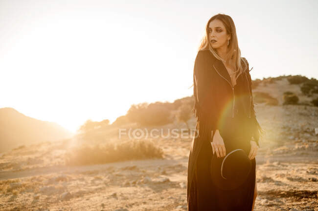Donna elegante in piedi sulla roccia in campagna — Foto stock