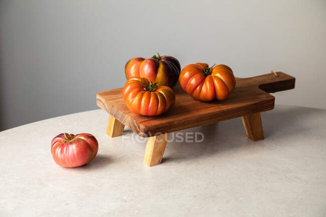 Dall'alto composizione con pomodori rossi crudi disposti su tavola di legno su tavolo di marmo — Foto stock