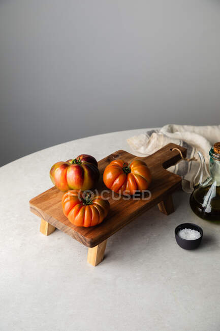 Composición con tomates rojos en la mesa - foto de stock