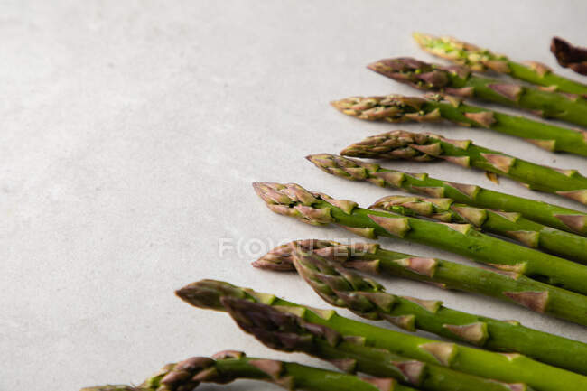 Flat lay of fresh asparagus on white marble table — Stock Photo