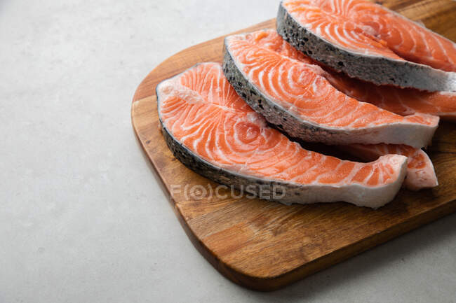 Bistecche di pesce fresco su tavola di legno — Foto stock