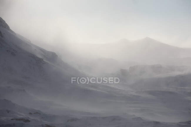 Vista de la escena rocosa nevada con niebla - foto de stock