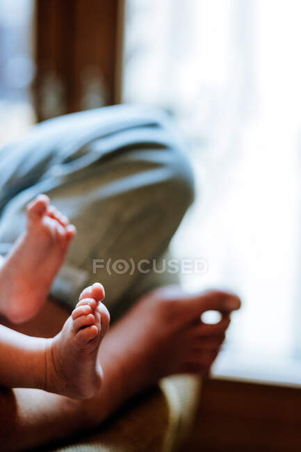 Mãe de colheita com bebê sentado perto da janela — Fotografia de Stock