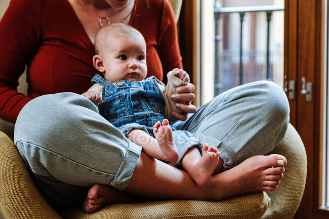 Mother with baby sitting near window — Stock Photo