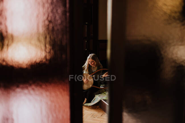Mulher tocando lira em casa — Fotografia de Stock