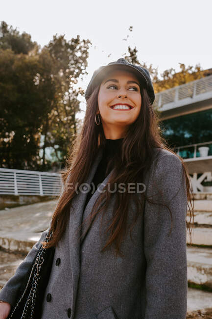 Позитивная женщина на потрепанных ступенях в парке — стоковое фото