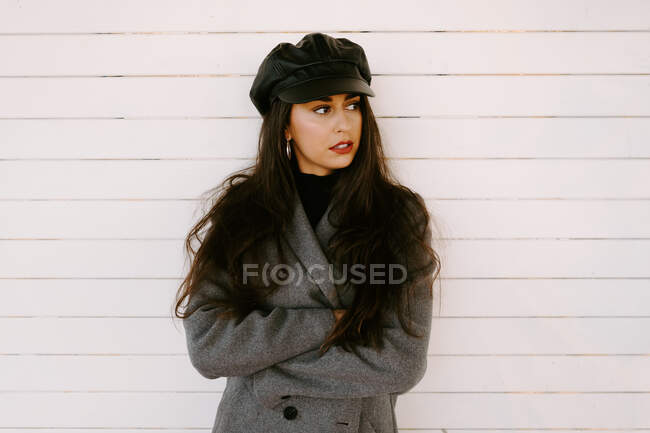 Confident young woman near white wall — Stock Photo