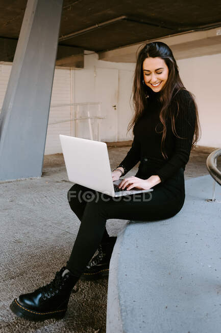 Female freelancer using laptop in courtyard — Stock Photo