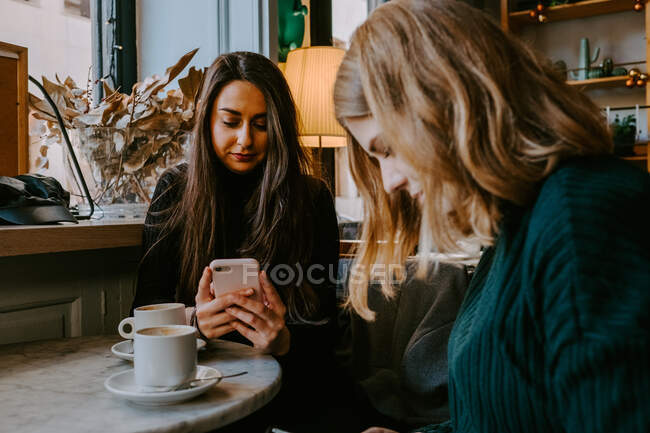 Amigos do sexo feminino descansando no café acolhedor — Fotografia de Stock