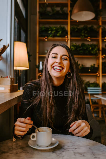 Entzückte Frau trinkt Kaffee im Café — Stockfoto