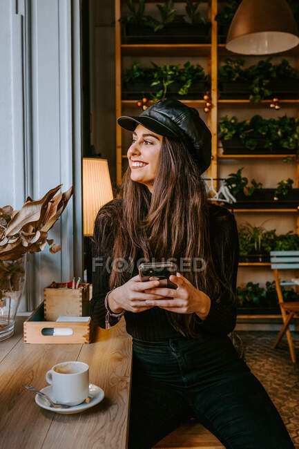 Giovane donna utilizzando smartphone in caffè — Foto stock