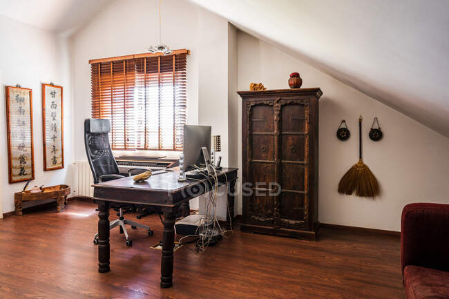 Робоче місце з вінтажними дерев'яними меблями і східним декором в сучасній квартирі — стокове фото