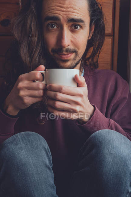 Бородатый мужчина отдыхает с горячим напитком — стоковое фото